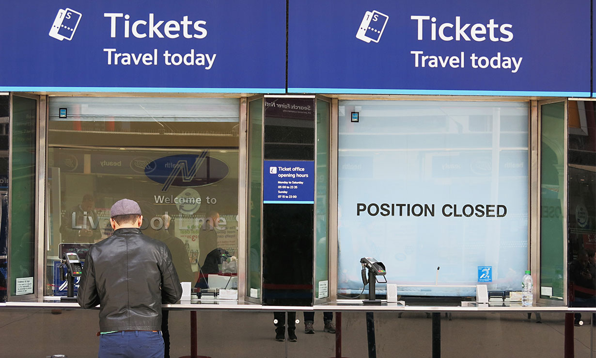 Image of one open train ticket office with a closed one next to it. The closed one in large black letters has written across it "position closed".